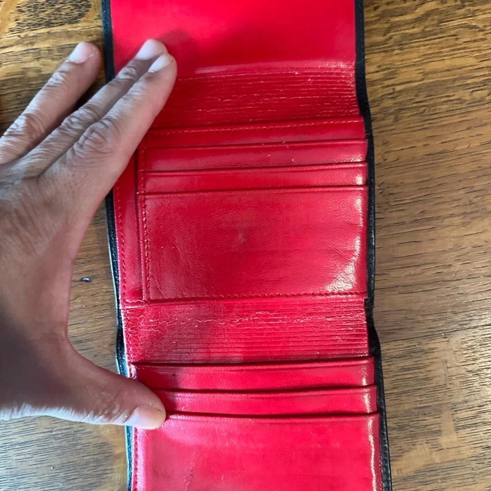 Black leather wallet with a red interior.